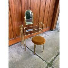 a small stool with a mirror on it in front of a wooden wall and door