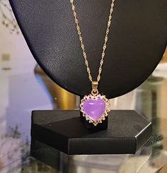 This diamond heart necklace has a centered purple stone. Gold colored. Purple is connected to the divine, the crown chakra and the third eye. Great piece to have on for great intentions. Gold And Purple Necklace, Elegant Heart-shaped Amethyst Necklace, Elegant Purple Heart Pendant Necklace, Purple Gemstone Jewelry For Valentine's Day, Purple Heart Pendant Jewelry For Valentine's Day, Purple Gemstone Heart Pendant Jewelry, Purple Amethyst Jewelry With Heart Charm, Heart Pendant Amethyst Jewelry, Purple Heart-shaped Birthstone Necklace