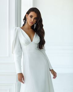 Fabric: Heavy Satin Cotton 50%, Polyester 50% V-neck dress Puffed sleeves Long sleeves Bow on back detail Zipper on back Dress lenght: 125 cm/ 49,2 inSleeve length: 68 cm/ 26,7 in Colors: White, Sky-Blue, Dusty Pink V-neck Dress With Elastic Sleeves For Brunch, Formal V-neck Mini Dress With Pleated Sleeves, Elegant V-neck Midi Dress With Elastic Sleeves, Fitted V-neck Puff Sleeve Dress For Wedding, Formal Dress With Structured Shoulders And Balloon Sleeves, Chic V-neck Long Sleeve Dress With Gathered Sleeves, Elegant Dresses With Structured Shoulders And Balloon Sleeves, Elegant Fitted V-neck Dress With Gathered Sleeves, Fitted Dress With Structured Shoulders And Bishop Sleeves