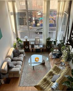 an aerial view of a living room with couches, coffee table, and stairs