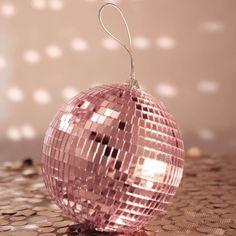 a pink disco ball ornament hanging from a string