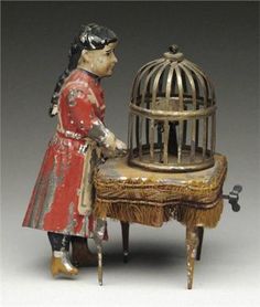 a figurine is standing next to a birdcage with a person in it