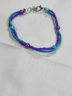 6.5" to 7.5" adjustable glass, seed beaded bracelet in two colors, purple and turquoise Purple Beaded Chain Bracelets With Round Beads, Purple Beaded Chain Bracelet With Round Beads, Adjustable Purple Beaded Bracelet With Beaded Chain, Adjustable Purple Beaded Chain Bracelets, Adjustable Purple Beaded Chain Bracelet, Adjustable Purple Beaded Friendship Bracelets, Adjustable Purple Bracelets With Tiny Beads, Adjustable Purple Bracelet With Tiny Beads, Adjustable Purple Beaded Bracelets With Spacer Beads