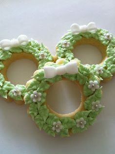 two decorated cookies with bows and flowers on them are sitting next to each other in the shape of wreaths