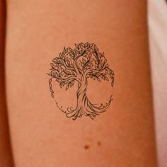 a tree tattoo on the back of a woman's arm