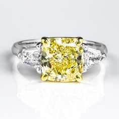 Celebrate that special day with this elegant canary diamond engagement ring! The center diamond is GIA certified 2.50 Ct. Cushion cut with natural Fancy Yellow color grade and SI1 clarity. split Metal : 14K Two Tone, 18K Two Tone, Solid Platinum/18K Yellow Gold Setting Type : Prong Total Carat Weight : 3.10 Carats Type : Natural Genuine Diamond Shape : Cushion Cut Carat Weight : 2.50 Ct. (GIA Certified) GIA Certification number : Included Polish-Symmetry : Contact us for a copy of GIA certificat Canary Diamond Engagement Ring, Fancy Yellow Diamond Ring, Radiant Cut Diamond Ring, 3 Stone Diamond Ring, Yellow Diamond Ring, Canary Diamond, Yellow Diamonds Engagement, Yellow Cushion, Yellow Diamond Engagement Ring