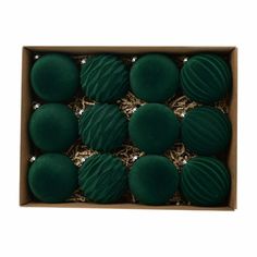 twelve dark green balls in a box with gold trimmings on the top and bottom