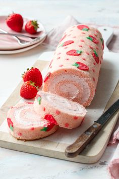 sliced strawberry pound cake sitting on top of a cutting board next to a knife and strawberries