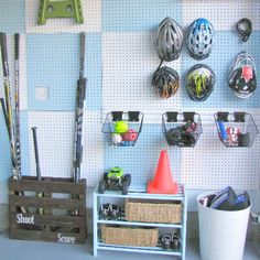 the pegboard organization system is organized with baseball bats, helmets and other sports equipment