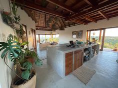 an open kitchen and living room area in a house with large windows looking out onto the countryside