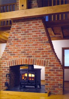 a wood burning stove sitting inside of a brick fireplace