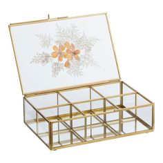 a gold and glass jewelry box with flowers on it