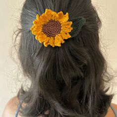 a woman wearing a sunflower hair clip