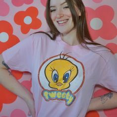 a young woman wearing a pink t - shirt with an angry bird on it's chest