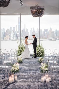 a bride and groom standing in front of an outdoor ceremony setup with candles on the ground