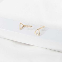 Wir präsentieren unsere winzigen dreieckigen Ohrstecker aus Gold, die perfekte Mischung aus minimalistischem Stil und modernem Charme. Diese Ohrringe bestehen aus zarten dreieckigen Ohrsteckern, die mit Präzision und Liebe zum Detail gefertigt wurden. Sie sind aus hochwertigem Gold gefertigt und bieten einen zeitlosen und doch modernen Look, der jedes Outfit mühelos ergänzt.

 Erweitern Sie Ihre Schmuckkollektion mit unseren geometrischen Ohrsteckern in Dreiecksform. Ob allein getragen für ein Minimalist Triangle Jewelry For Pierced Ears, Trendy Gold Triangle Earrings, Elegant Everyday Triangle Earrings, Gold Triangle Minimalist Earrings, Minimalist Gold Triangle Earrings, Minimalist Triangle Earrings For Everyday, Chain Threader Earrings, Wire Jewelry Earrings, Triangle Stud Earrings