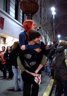 two people hugging each other on the street