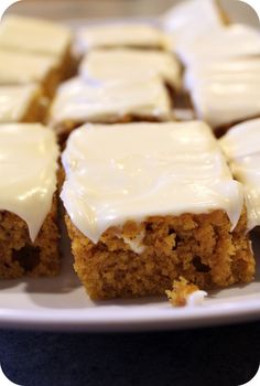 there are many pieces of carrot cake on the plate and one is frosted with icing