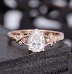 a rose cut diamond engagement ring on top of a wooden block with diamonds around it