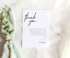 a thank card with green leaves on it next to a white envelope that says, thank you