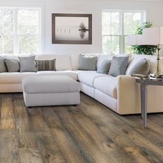 a living room with wood flooring and white furniture