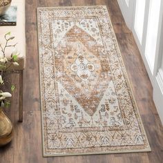 a large area rug is on the floor next to a vase with flowers in it