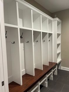 a row of white lockers sitting next to each other on top of a wooden bench