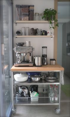 a kitchen area with shelves, pots and pans on the counter top in front of an open refrigerator