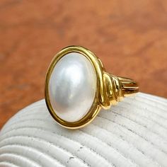 New, but old pieces, never worn, recently acquired from a premier jeweler located in Minneapolis, MN for many years- a rare opportunity! 18KT yellow Ggld genuine, bezel-set, white, oval, mabe pearl ring. Size 6.75 Sizable by us for a fee or your local jeweler Weight: 10.3 grams Band width: 3mm in back Pearl measures: 15mm x 11mm oval mabe pearl Stamped 18k By Honora Timeless Oval Rings With High Luster, Classic Gold Pearl Ring With Polished Finish, Heirloom High Luster Oval Pearl Ring, Classic Oval Ring With High Luster, Classic Oval Rings With High Luster, Yellow Gold Oval Pearl Ring With Polished Finish, Oval Yellow Gold Pearl Ring With High Luster, Oval Pearl Ring In Yellow Gold With High Luster, Classic Oval High Luster Ring