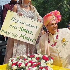 a man and woman standing next to each other holding a sign that says if you want our sister pay up mister