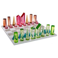 a set of colorful glass pieces sitting on top of a chess board