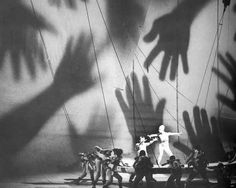 the cast of grease dancing on stage in front of palm trees with their hands casting shadows