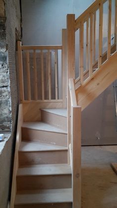 a wooden stair case in a room under construction