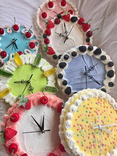 four cakes with different designs on them sitting next to each other in front of a white sheet