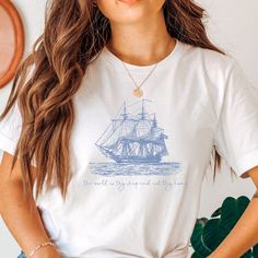 a woman wearing a t - shirt with a ship on it