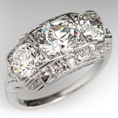 a three stone diamond ring with two rows of diamonds on the band and side stones