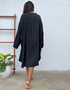 Relax in style with the Aura shirtdress, a unique take on traditional loungewear. Made from breathable double gauze cotton, it's perfect for casual wear out, at home, or even as a beach coverup. The button-down design adds a touch of style and versatility to your wardrobe, ensuring comfort and convenience as you go about your day. Black Cotton Relaxed Fit Shirt Dress, Black Cotton Shirt Dress With Relaxed Fit, Black Relaxed Fit Cotton Shirt Dress, Oversized Long Sleeve Tunic For Beach Cover-up, Oversized Tunic For Loungewear, Oversized V-neck Shirt Dress For Beach, Oversized V-neck Shirt Dress For The Beach, Long Sleeve Cotton Shirt Dress For Beach, Long Cotton Shirt Dress For Vacation