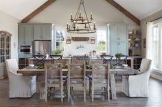 a dining room table with chairs and a chandelier hanging from it's ceiling