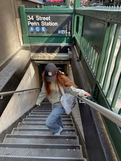 a woman with red hair walking up some stairs