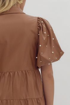 The cutest little dress! Cafe colored faux leather button up dress with tiered ruffled bodice. Features puff sleeves adorned with pearl embellishments. Collard Leather Button Up, Pearl Dress, Pearl Leather, Button Up Dress, Little Dresses, Puff Sleeves, The Cutest, Puff Sleeve, Bodice