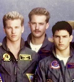 three men in pilot's uniforms are posing for a photo with another man behind them