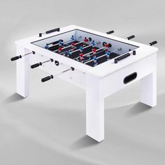 the foosball table is white with red and blue balls on it's legs