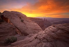 the sun is setting over some rocks in the desert