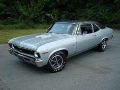 an old muscle car parked in a parking lot