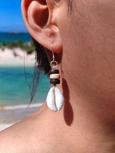 Cowrie Shell Earrings Natural Beach Earrings Perfect Boho Style Earrings in Sterling Silver Hook Embrace the essence of the beach and the free-spirited charm of boho style with our Cowrie Shell Earrings. Each earring features a beautifully polished natural cowrie shell, capturing the ocean's timeless allure. These earrings are designed to complement any outfit, whether you're strolling along the shoreline or dancing the night away at a summer festival. Key Features: Natural Cowrie Shells: Sourced from pristine beaches, each shell retains its unique shape and texture, making every pair one-of-a-kind. Boho Style: The bohemian-inspired design adds a touch of effortless elegance and earthy vibes to your look. Sterling Silver Hooks: Crafted with high-quality sterling silver, the hooks are hypoa Bohemian Dangle Earrings For Beach, Nickel-free Bohemian Earrings For Vacation, Bohemian Nickel-free Earrings For Vacation, Bohemian Nickel Free Earrings For Vacation, Bohemian Earrings With Ear Wire For Vacation, Bohemian Drop Earrings For Vacation, Single Drop Earring For Vacation, Nickel-free Bohemian Earrings For Beach, Bohemian Nickel-free Earrings For Beach