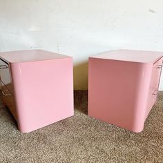 two pink boxes sitting next to each other on the floor