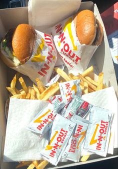 two hamburgers and french fries in a box