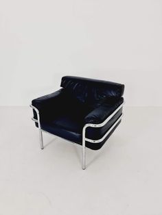 a black leather chair sitting on top of a white floor