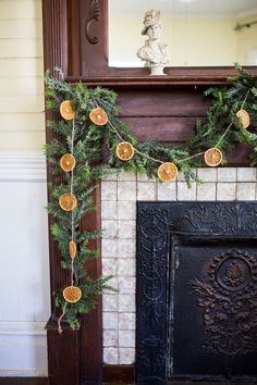 a fireplace decorated with oranges and greenery