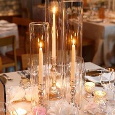 candles are lit on the centerpieces in this elegant table setting